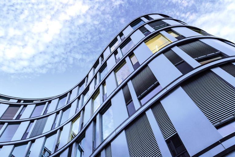 Modern and curved apartment building with louvres